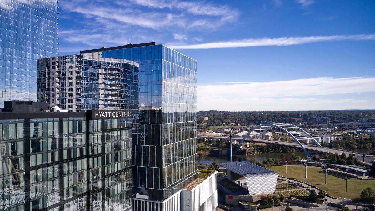 Hyatt Centric Downtown Nashville — a modern glass tower overlooking the river and bridges.