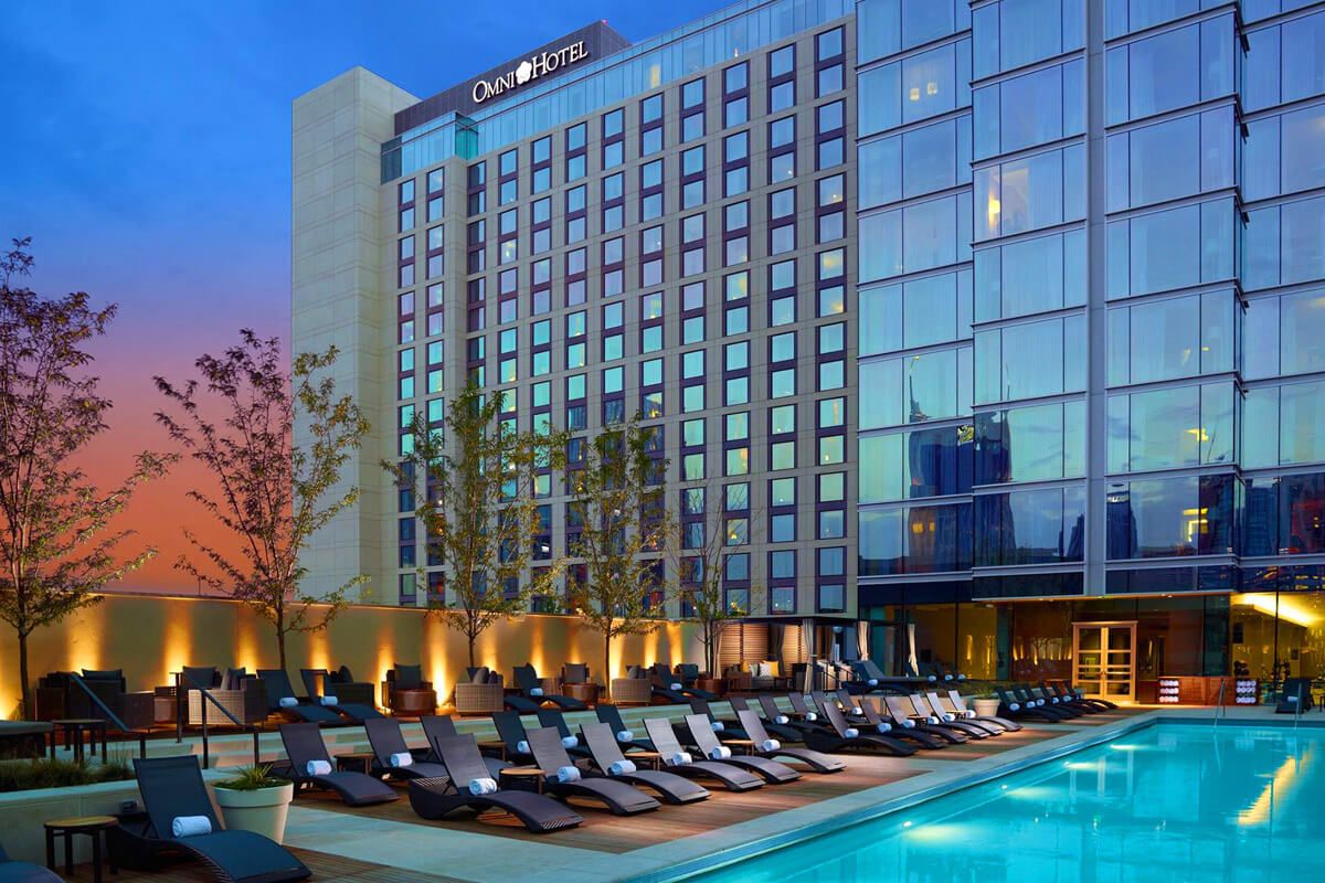 Omni Nashville Hotel — the hotel exterior at dusk with its rooftop pool deck in the foreground.