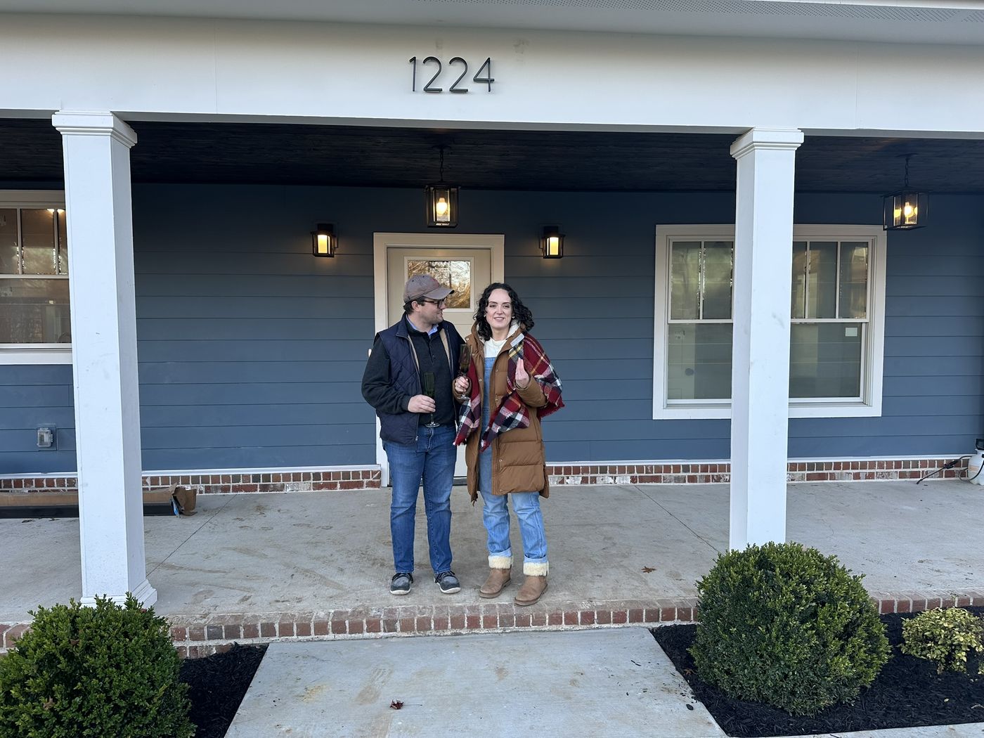 Samantha and Andrew standing together on the front porch at 1224 Howard Avenue.