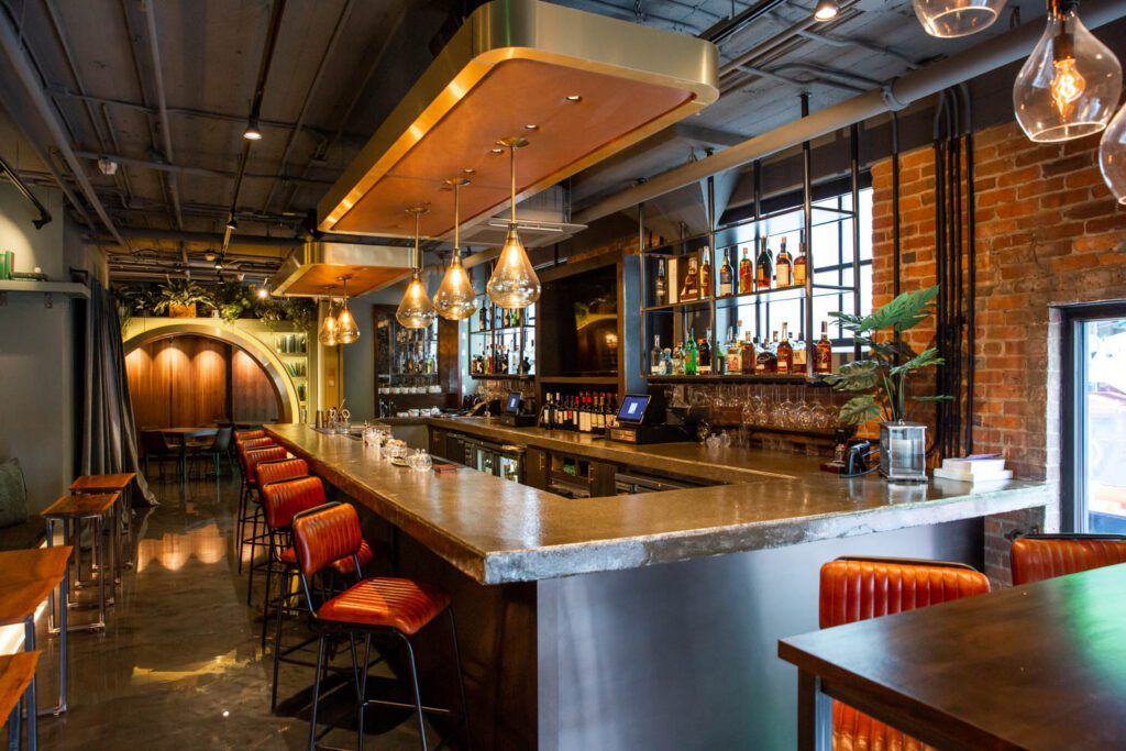 The bar at the Nashville City Club — warm lighting, exposed brick, and leather barstools.